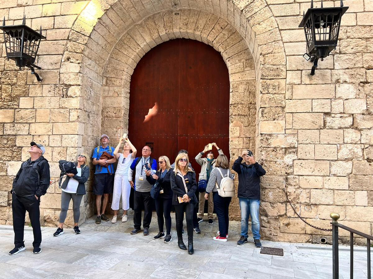 Turistas hacen fotos a la Catedral desde el Palau de l'Almudaina