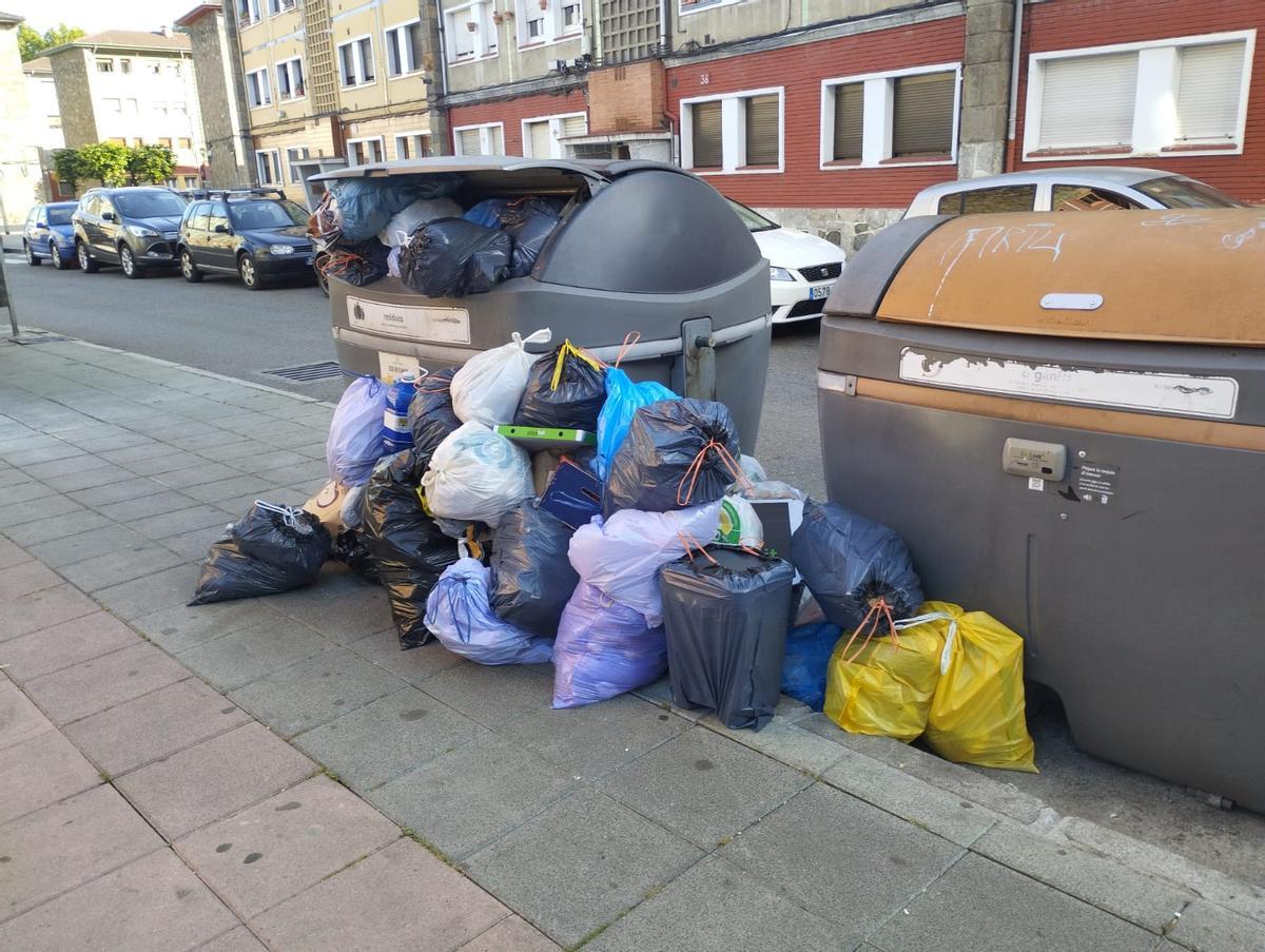 Basura acumulada junto a los contenedores sin vaciar en Langreo