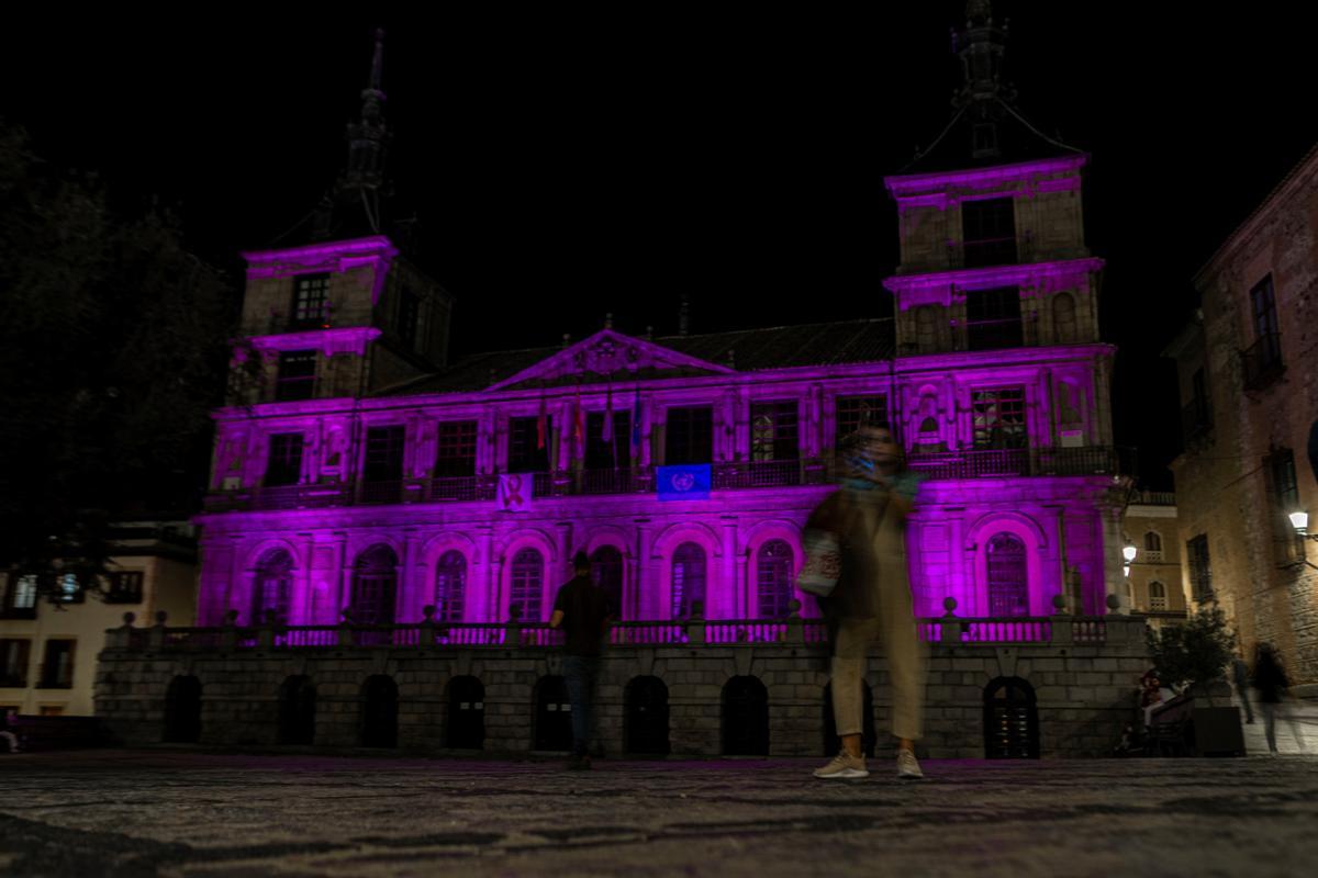 La fachada del ayuntamiento de Toledo iluminada este martes con luces de color rosa