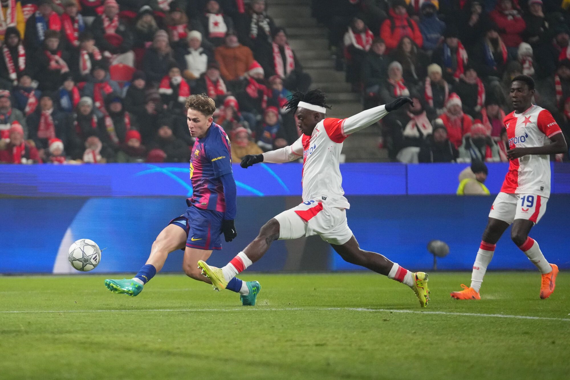 Barcelona's Fermin Lopez, left, scores his side's opening goal past Slavia's David Moses, center, during the Champions League opening phase soccer match between Slavia Prague and Barcelona in Prague, Czech Republic, Wednesday, Jan. 21, 2026. (AP Photo/Petr David Josek)