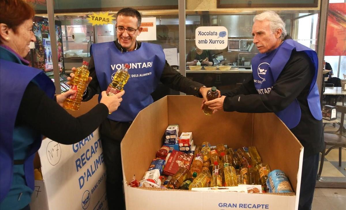 Voluntarios ordenan las gigantescas cajas que guardan los alimentos recogidos en el Mercat de Santa Caterina, de Barcelona. 