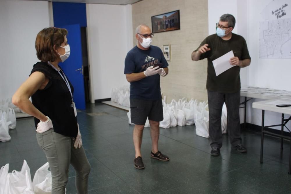 Preparativos y reparto de raciones para cocinar arroz al horno por el voluntariado de "Coronavirus amb Cor" de Alaquàs.