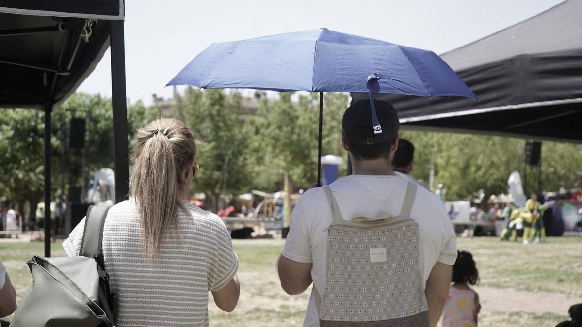 Sota el paraigua per protegir-se de la calor, diumenge a la Festa Major de Sant Joan