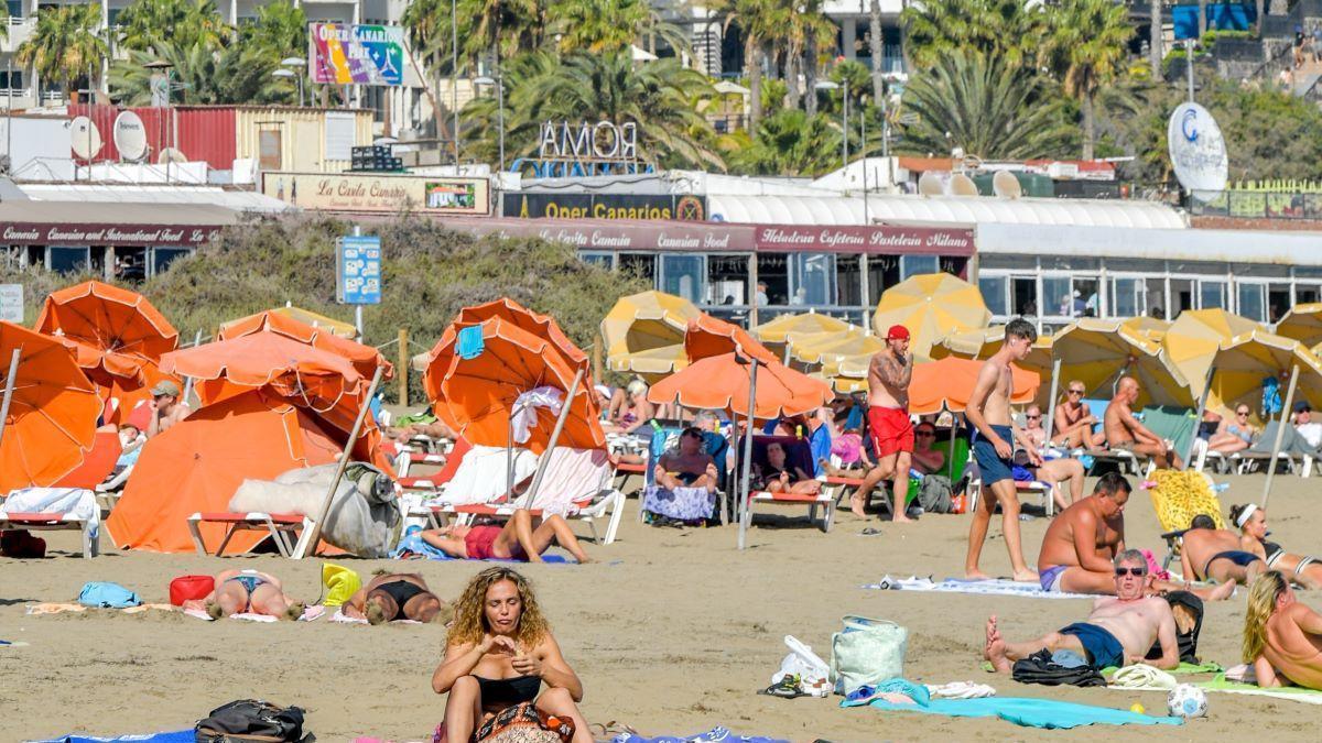 Turistas disfrutan del sol en una playa de Canarias.