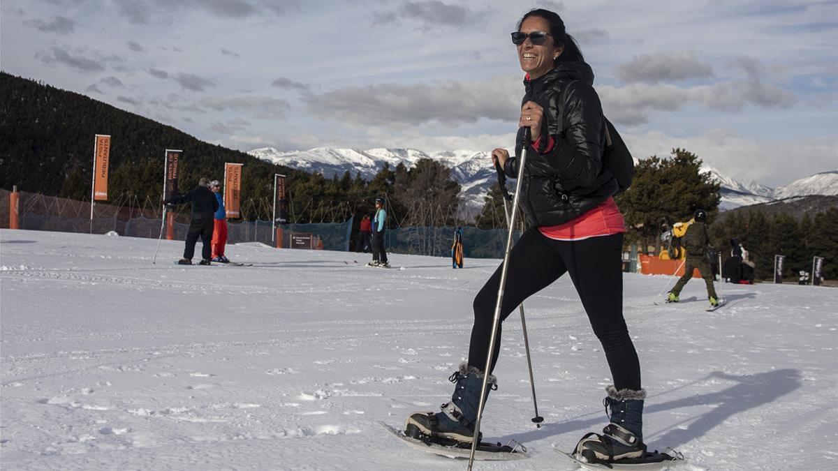 Una aficionada camina con raquetas de nieve por las pistas de La Molina.