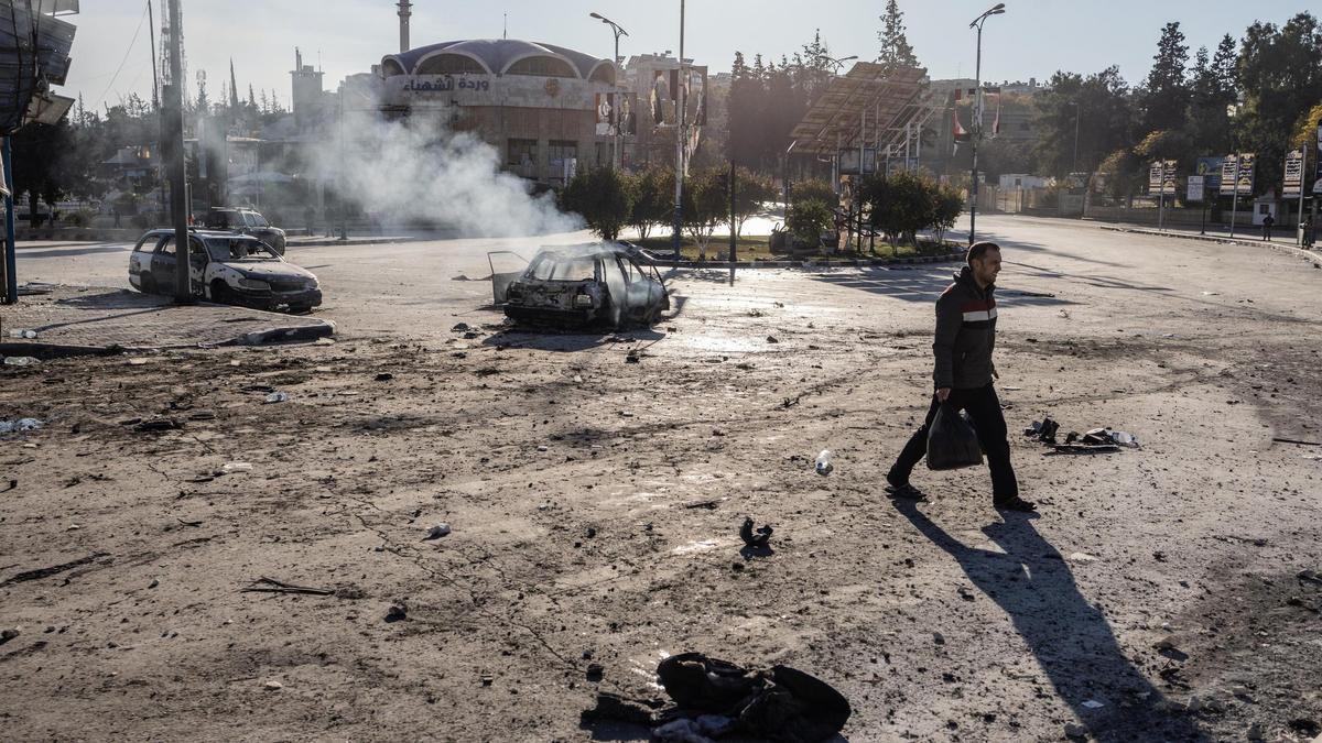 Un hombre camina ante un vehículo en llamas en la ciudad siria de Alepo, en una imagen de archivo.