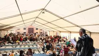 La lluvia no impide la multitudinaria comida en la calle de las fiestas del Oviedo Antiguo: "Nada nos va a estropear el plan"