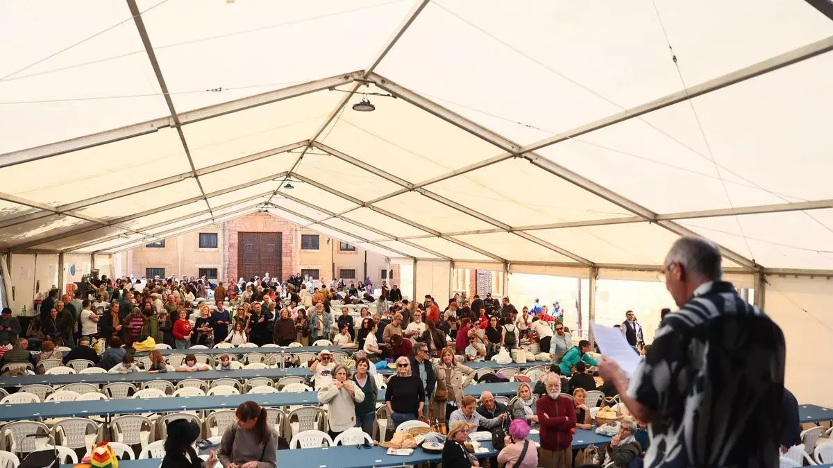 La lluvia no impide la multitudinaria comida en la calle de las fiestas del Oviedo Antiguo: "Nada nos va a estropear el plan"