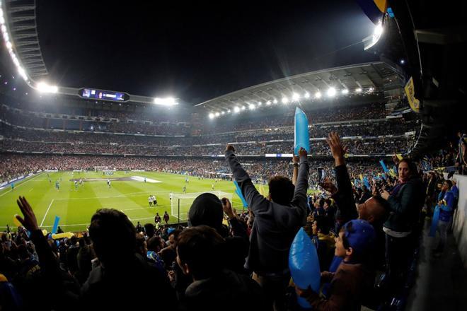 Aficionados de Boca Juniors animan en la grada del estadio Santiago Bernabeu donde esta noche se disputará el partido de vuelta de la final de la Copa Libertadores entre el River Plate y el Boca Juniors.