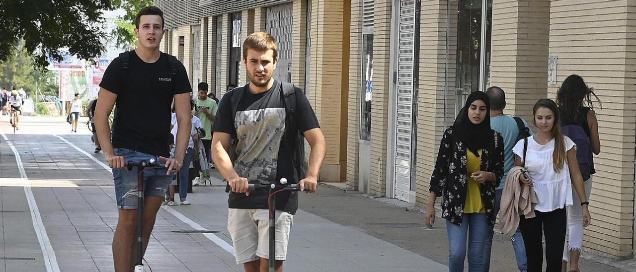 Dos jóvenes circulan con un patinete eléctrico por una calle de Castelló, en una imagen de archivo.