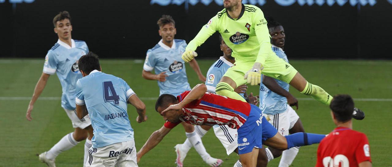 Iván Villar despeja de puños un balón por encima de Javi Fuego, ante la mirada de Pablo Pérez y varios defensas del Celta.