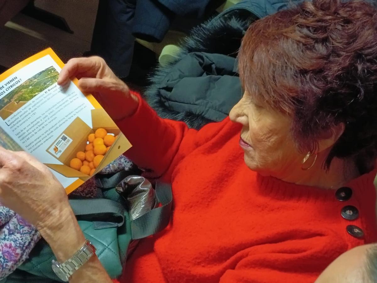 Una asistente al acto observa el folleto informativo.