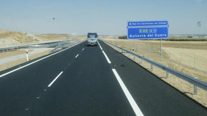 Un autobús circula por la autovía A-11.