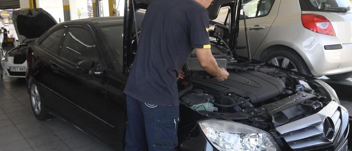 Un mecánico trabaja en un taller de reparación de vehículos.