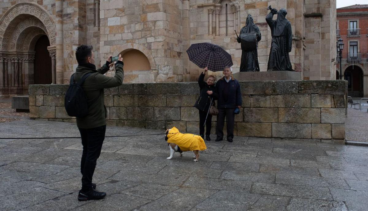 Turistas se fotografían junto al Merlú, junto a la iglesia de San Juan de Puerta Nueva. | Ana Burrieza