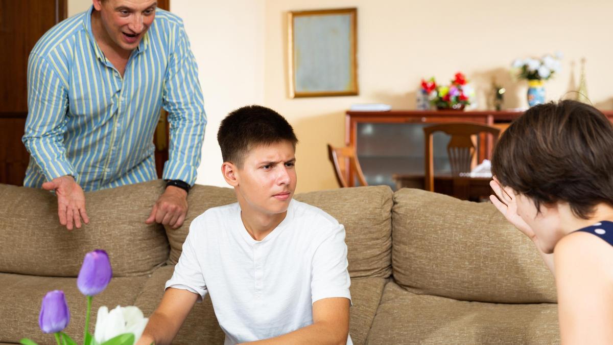 Un chico, confundido, escucha a su padre y a su madre hablándole a la vez