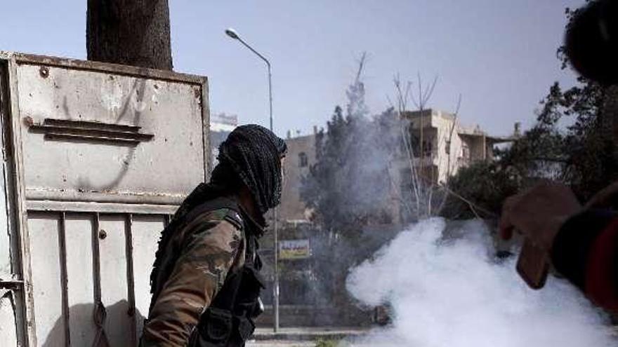 Un rebelde sirio se dispone a lanzar una granada de mano.  // Efe