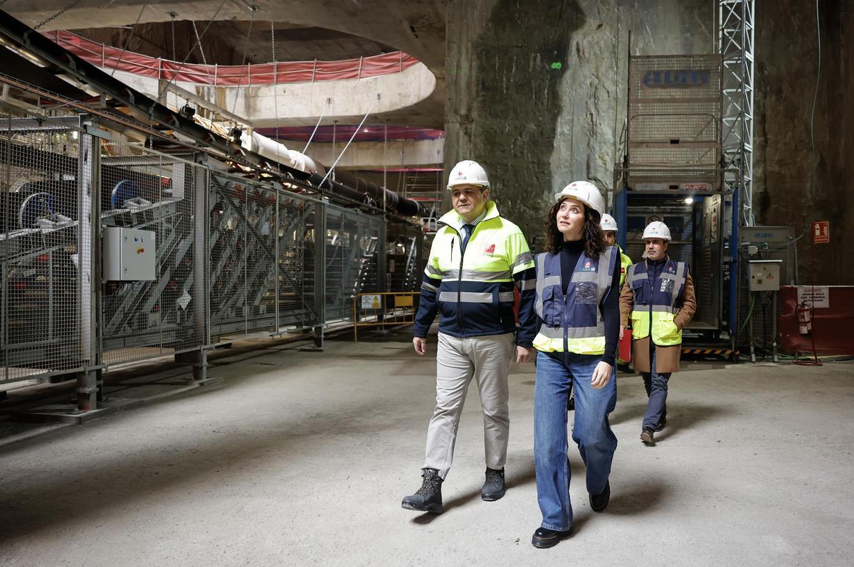 La presidenta de la Comunidad de Madrid, Isabel Díaz Ayuso, y el consejero de Transportes, Jorge Rodrigo, en la futura estación de Comillas de la Línea 11, desde donde ha comenzado a operar la tuneladora Mayrit.