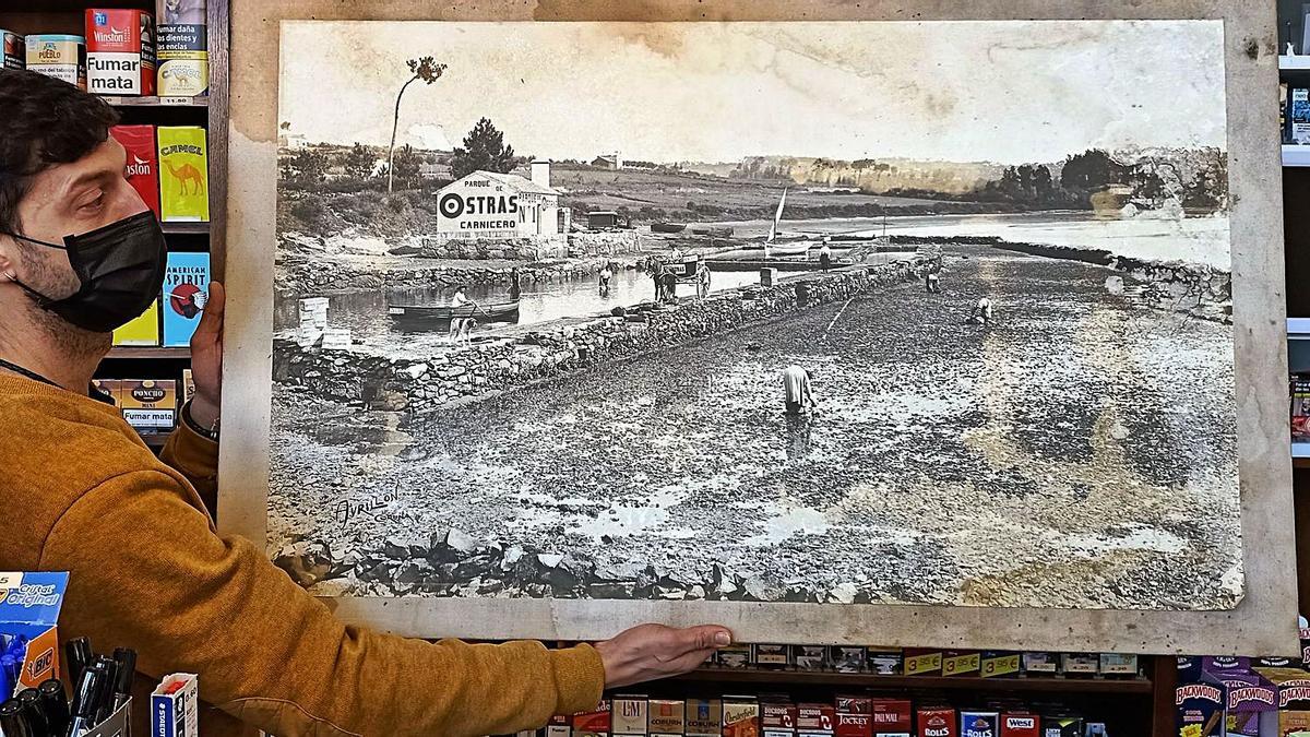 Diego Rodríguez, con la foto del antiguo parque de ostras. que estuvo colgada muchos años en la casa.  | // M. V.