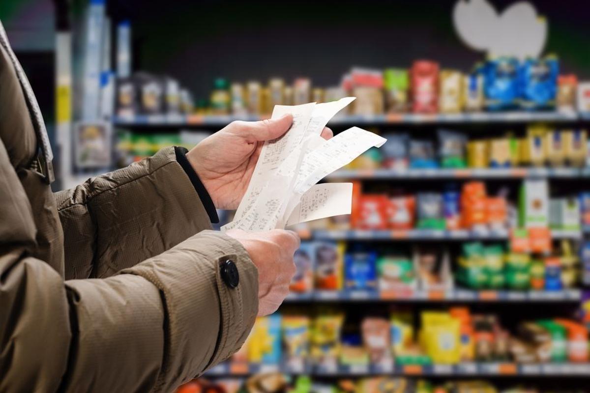 Un hombre revisa la cuenta del supermercado Un hombre revisa la cuenta del supermercado