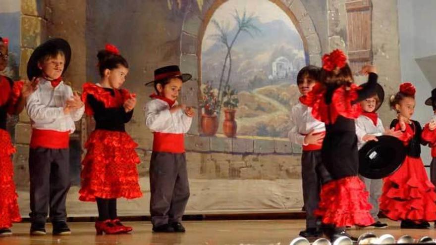 Varios niños, tocando las palmas sobre el escenario.