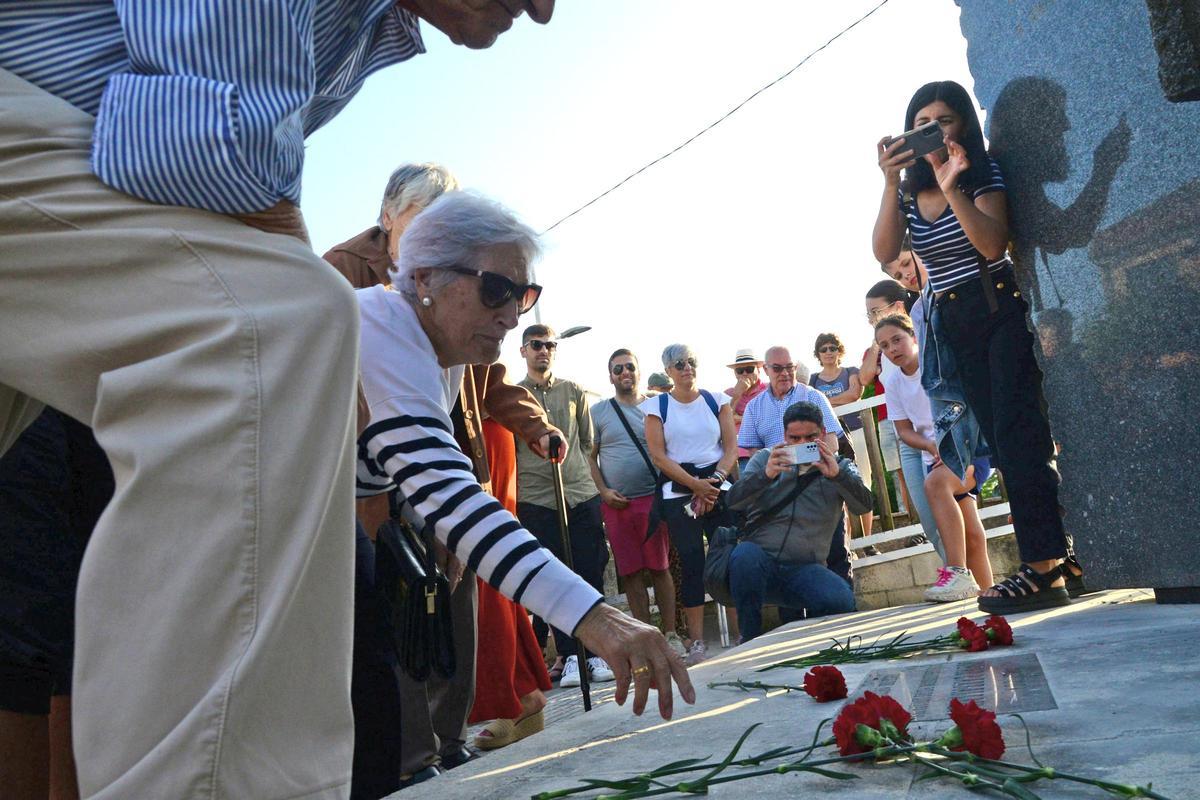 María de los Ángeles Rey, de 92 años, deposita un clavel sobre el adoquín que recuerda a su padre, Manuel Rey Cruz.