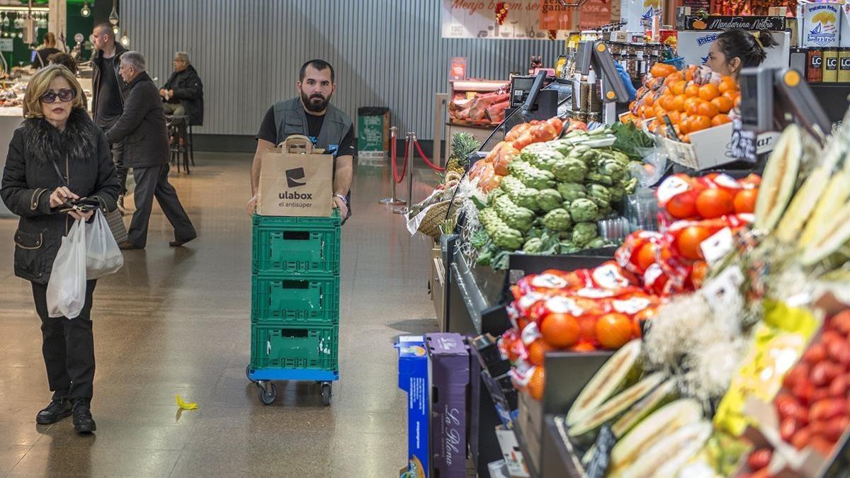 Un operario de Ulabox prepara varios pedidos en el mercado del Ninot.