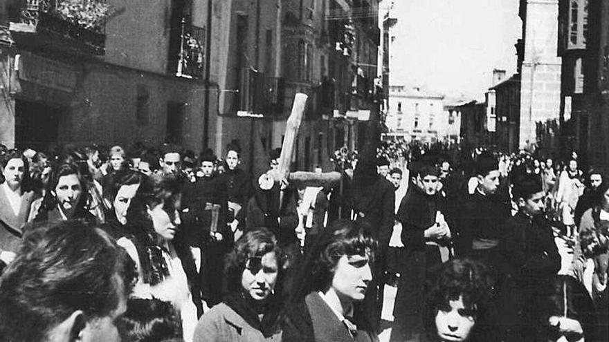 Toresanos acompañan a los cofrades que portan la cruz realizada con dos postes en la procesión de 1957.