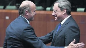 El ministre espanyol d’Economia, Luis de Guindos (esquerra) saluda el president del BCE, Mario Draghi, ahir.