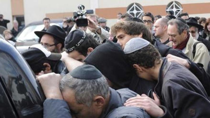 Decenas de personas tras un coche fúnebre en el exterior del Colegio Ozar Hatorah de Toulouse.  | efe