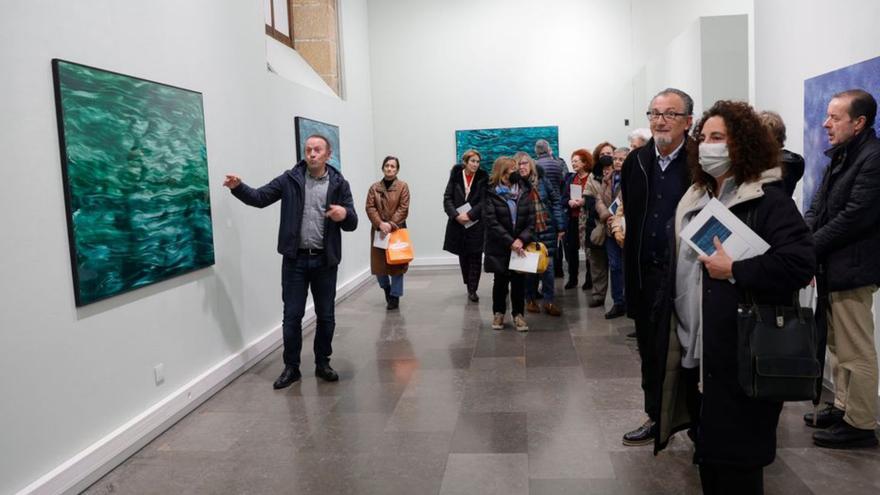 Guillermo Simón, a la izquierda, junto a una de sus obras, durante una visita guiada con los lectores de LA NUEVA ESPAÑA. | Miki López