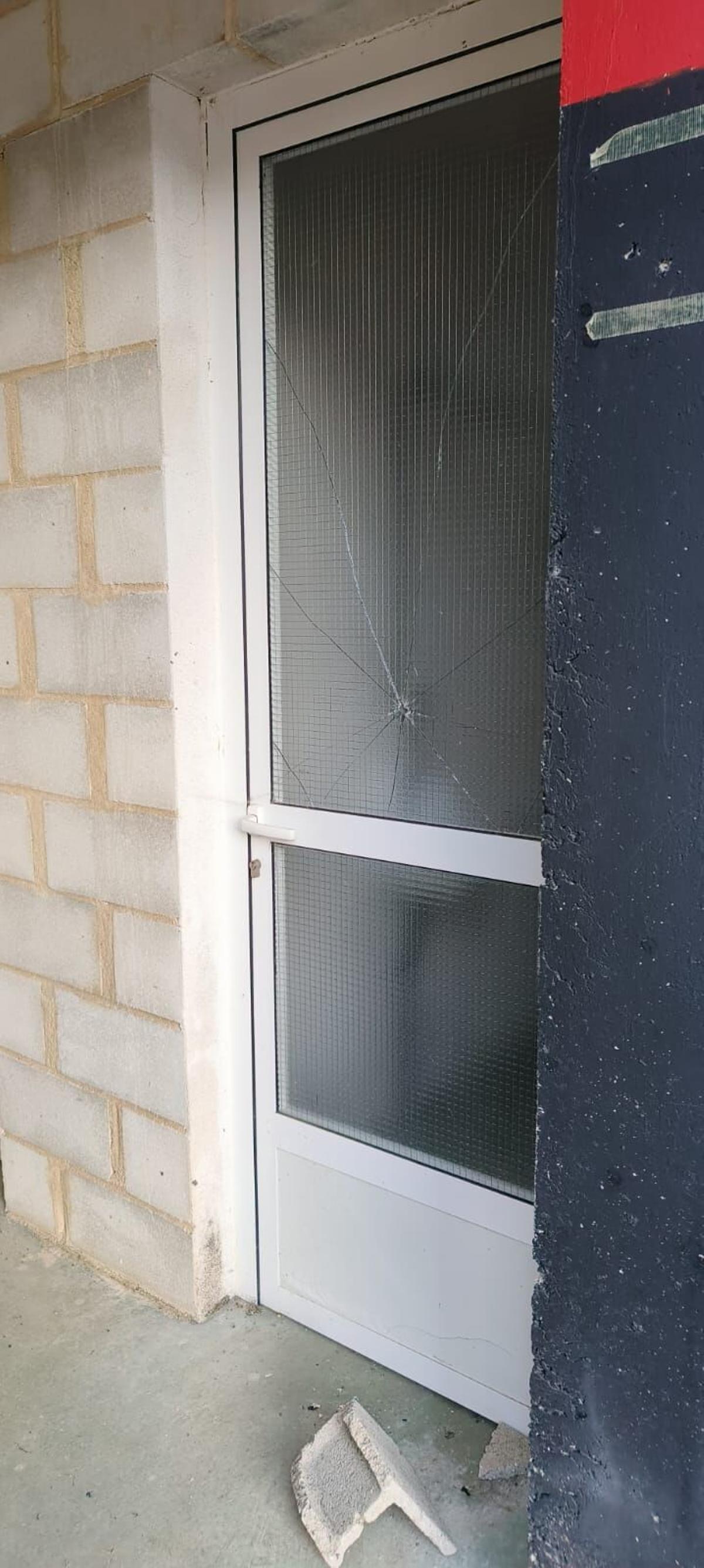 Destrozos en una puerta de los vestuarios del campo de fútbol.