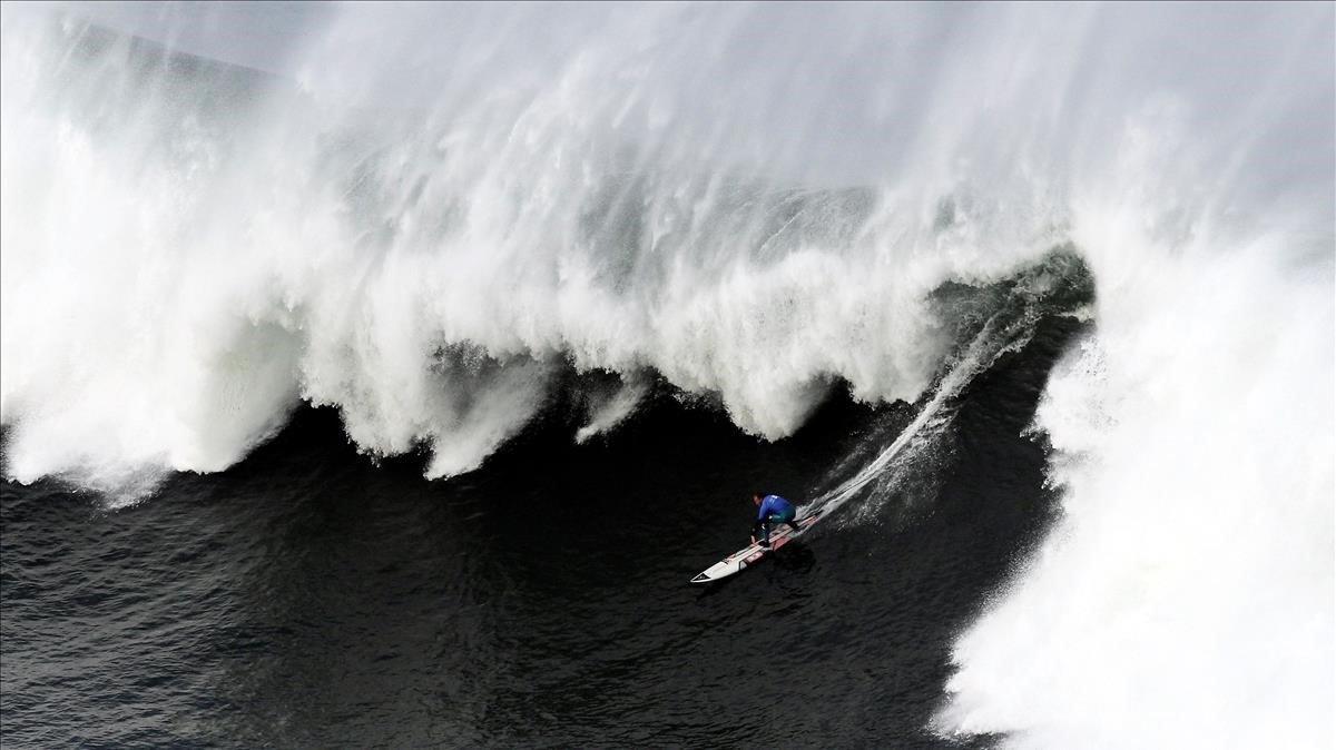 El surfista Andrew Cotton desciende una ola en la XIII edicion del Punta Galea Challenge en Getxo.