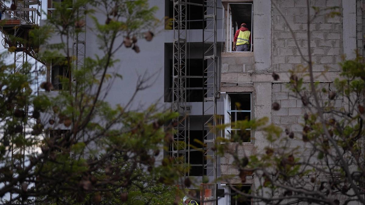 Dos operarios trabajan en la construcción de un edificio de viviendas.