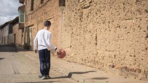 Un niño juega en las calles de un pueblo.