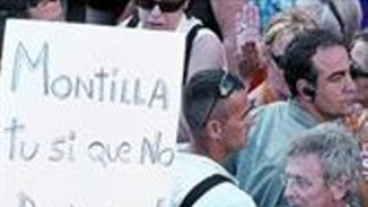 Montilla pasa junto a una pancarta crítica.