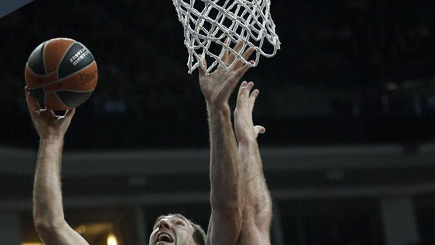 El pívot serbio del Unicaja, Vladimir Golubovic (c), intenta encestar ante Oguz Savas (d), del Fenerbahce Ulker.