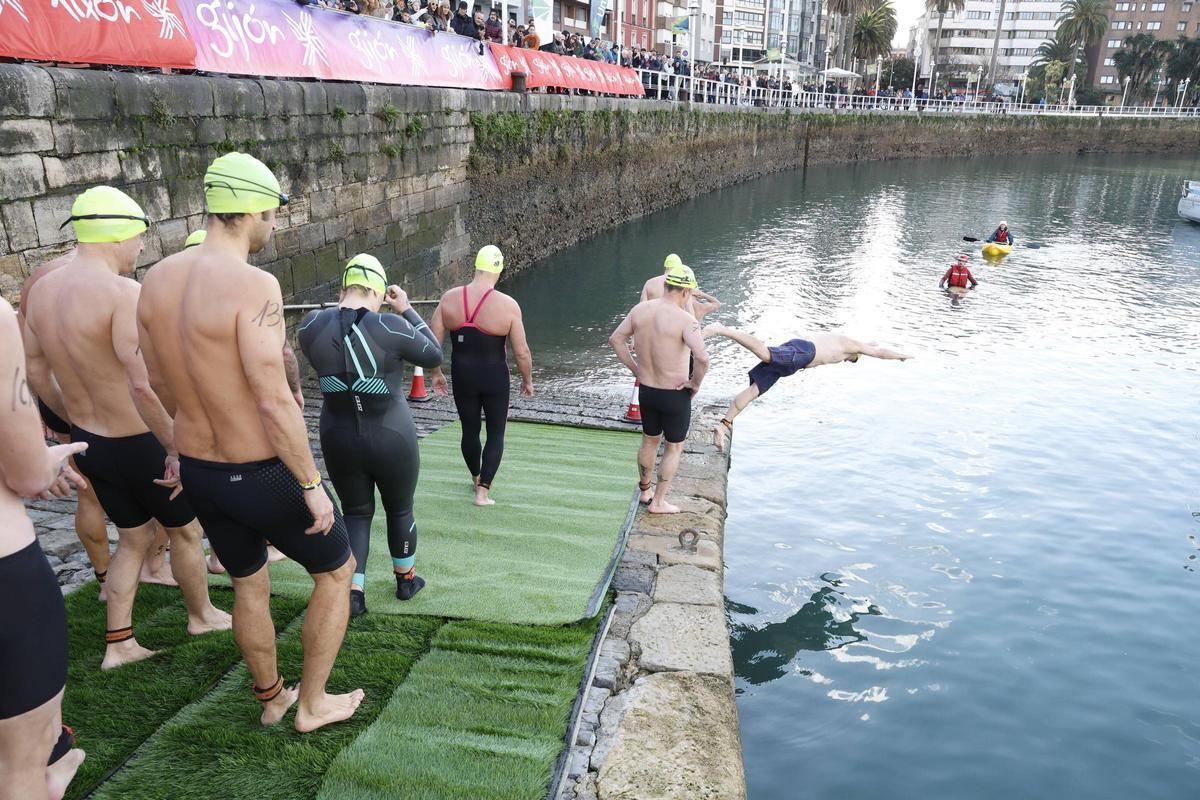 La travesía a nado de Navidad en Gijón congrega un año más a decenas de participantes (en imágenes)