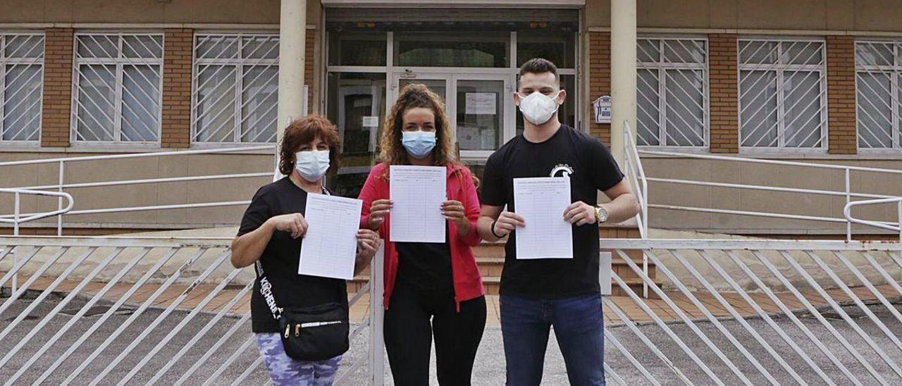 Representantes de &quot;La Flor&quot; de Lada, frente al consultorio, con las hojas de firmas.