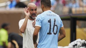 Guardiola conversa con Rodrigo en un partido del Manchester City.