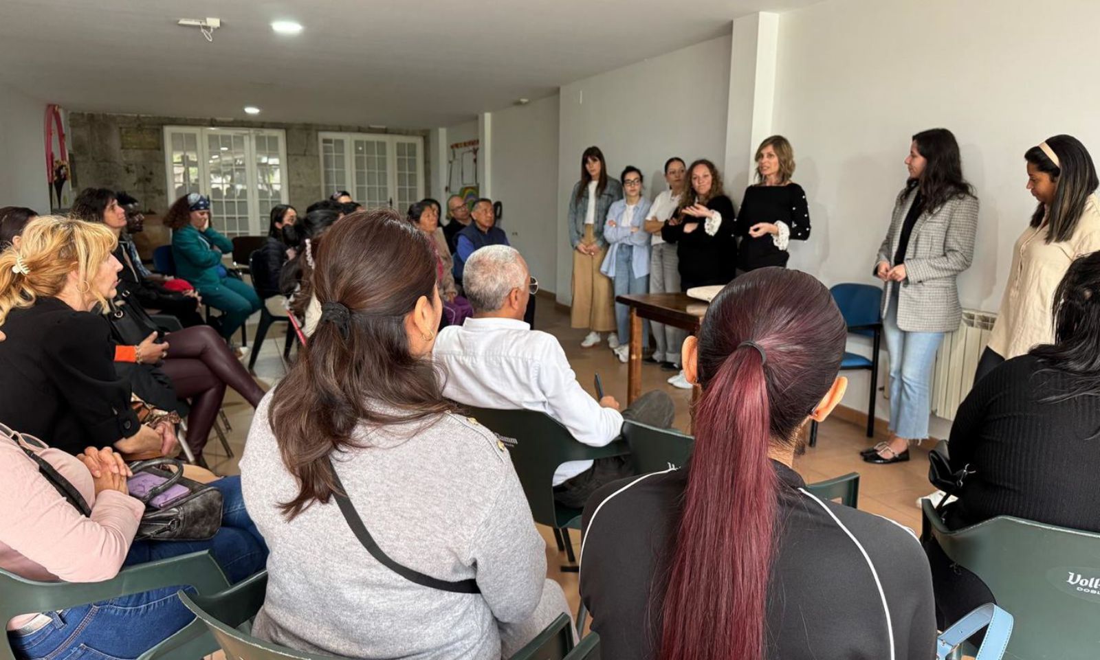 trabajador social hablando con familia inmigrante en oficina municipal