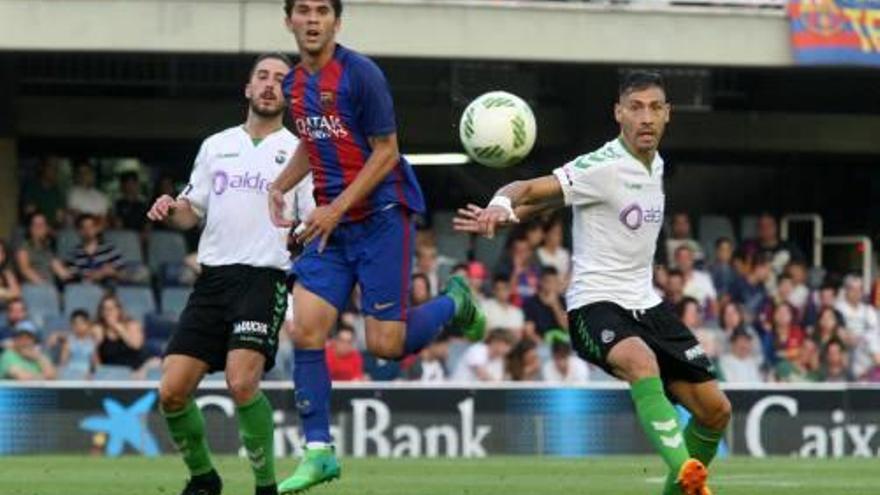 Carles Aleñà disputa una pilota entre dos jugadors del Racing.