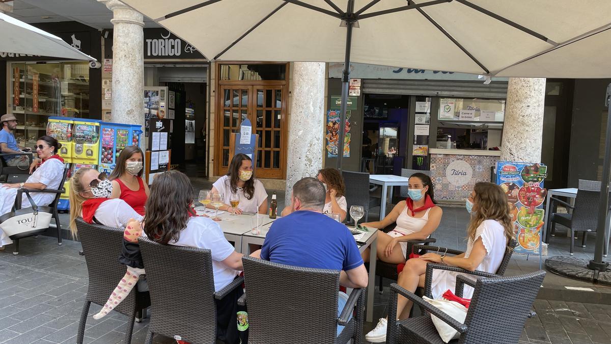 Clientes de una de las terrazas de la plaza del Torico, ataviados con la vestimenta habitual en las fiestas.