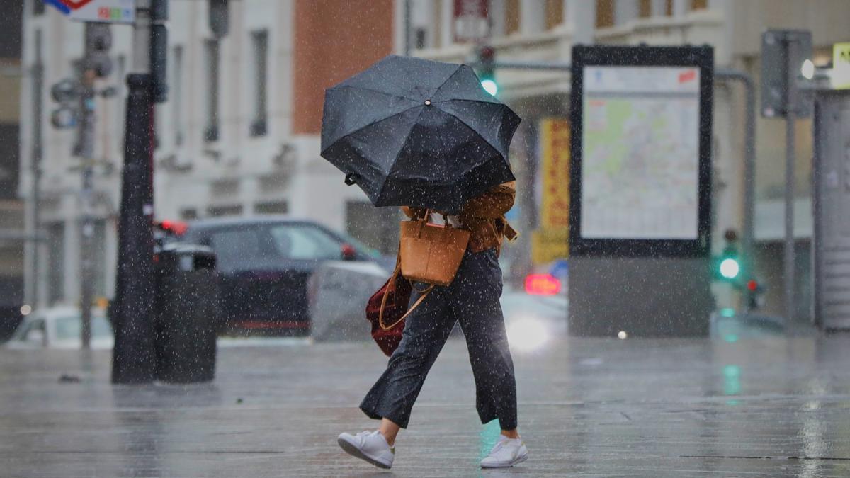 Archivo - Una persona camina por el centro de la capital en una jornada marcada por las lluvias en Madrid, (España)