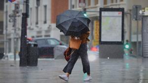 Archivo - Una persona camina por el centro de la capital en una jornada marcada por las lluvias y la bajada de temperaturas, en Madrid, (España), a 2 de octubre de 2020.