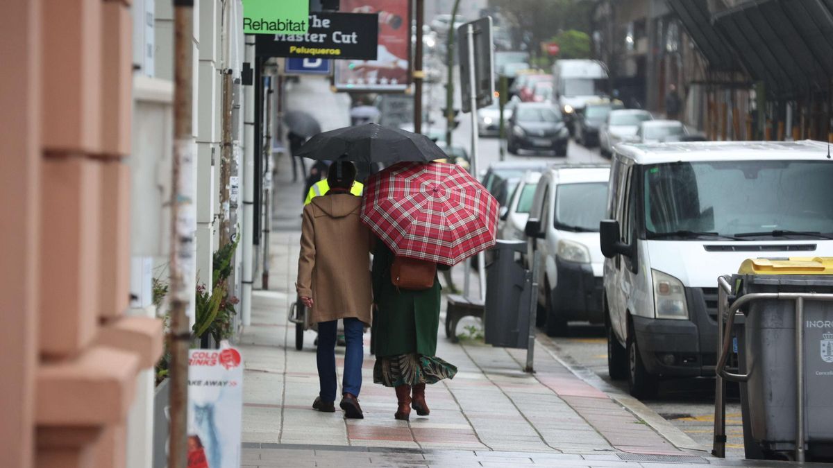 Personas paseando bajo la lluvia en A Coruña