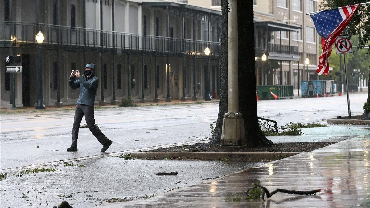 Un hombre fotografía la calle durante el huracán Sally. 