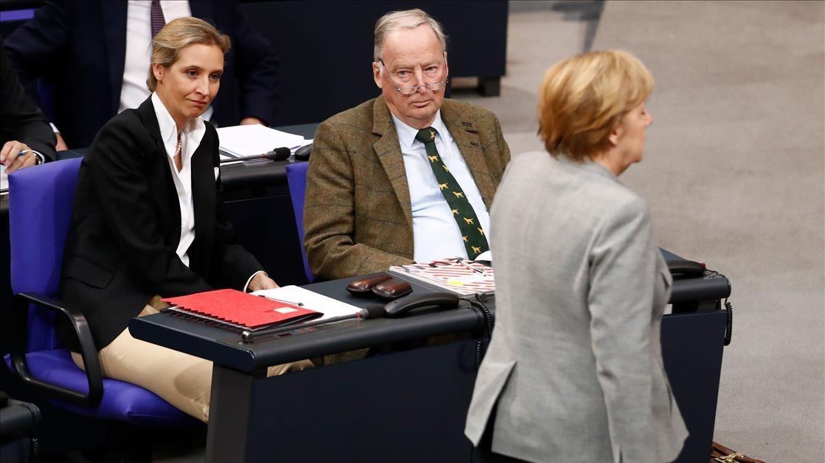 El cancillera Angela Merkel pasa frente a dos de los dirigentes de AfD, Alexander Gauland y Alice Weidel, en el Parlamento alemán. El cancillera Angela Merkel pasa frente a dos de los dirigentes de AfD, Alexander Gauland y Alice Weidel, en el Parlamento alemán.