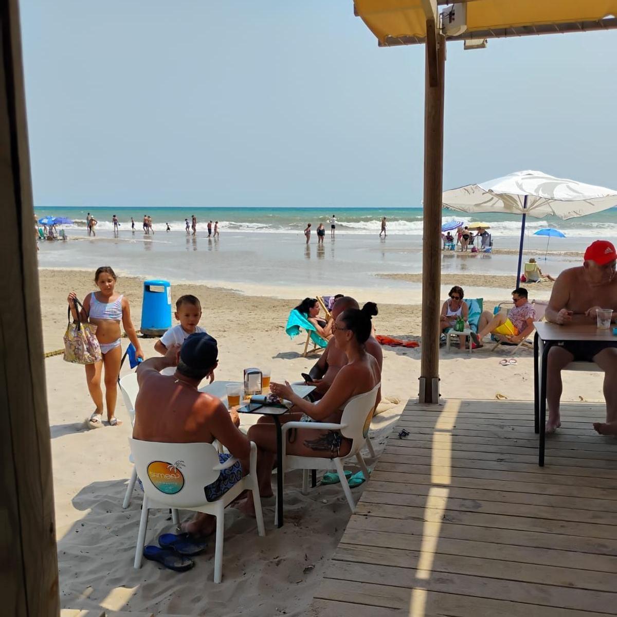El mar se adentra en el arenal en la playa de Motilla y llega casi a las mesas de los veraneantes.