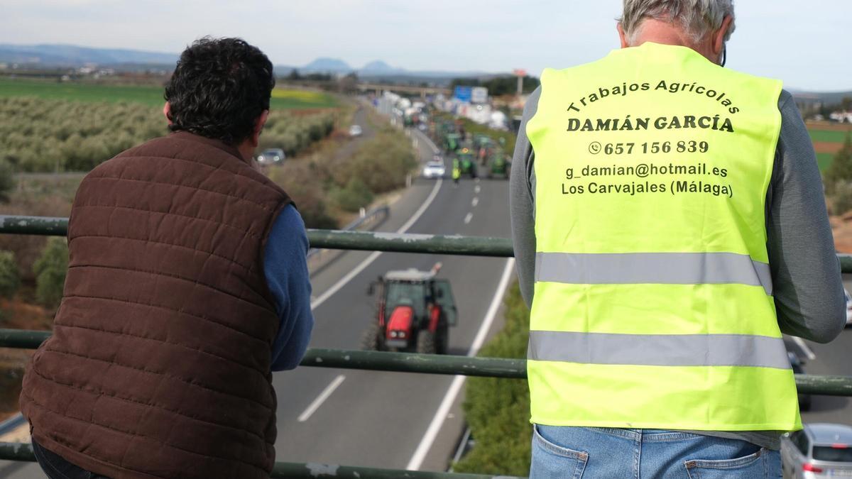 Dos agricultores observan la carretera durante la protesta de este miércoles.